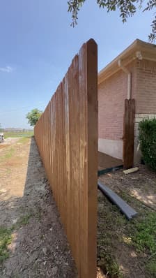 New cedar privacy fence beside a brick home