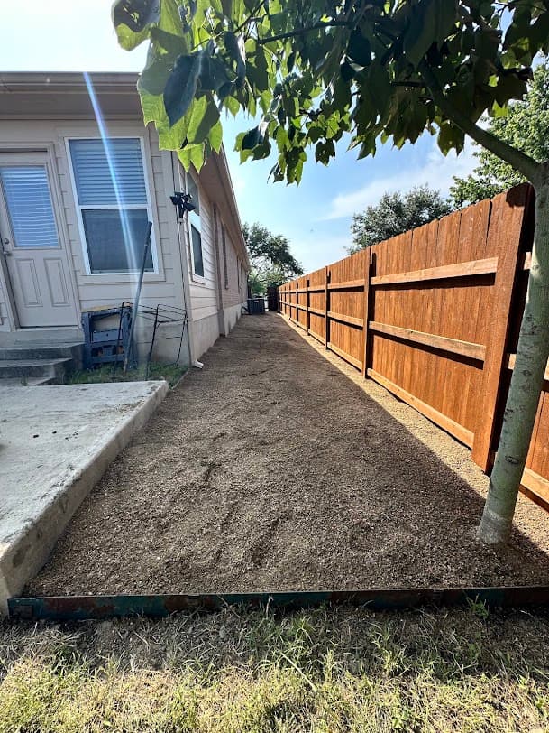 New cedar privacy fence and prepared side yard beside a home